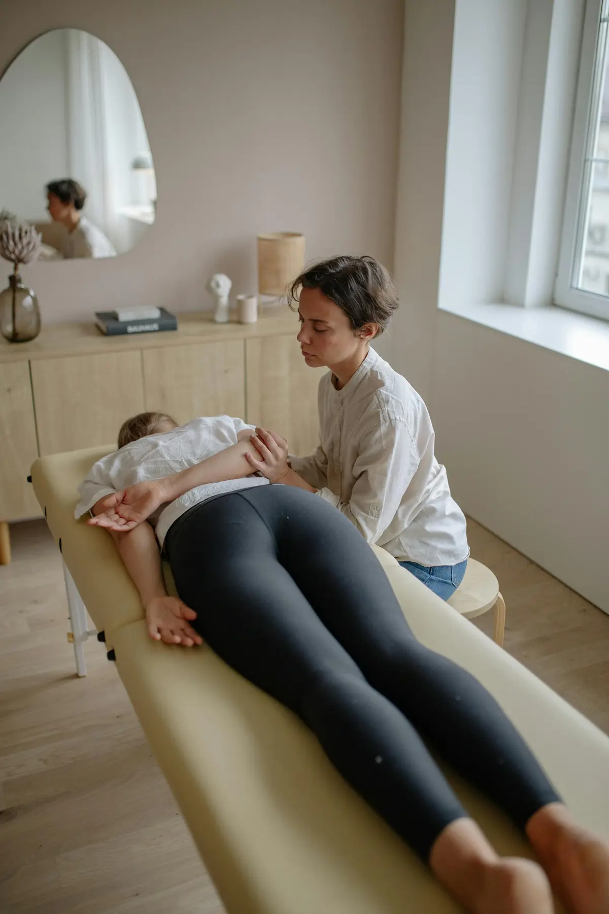 Physiotherapist providing hands-on treatment to a patient in a warm, modern clinic