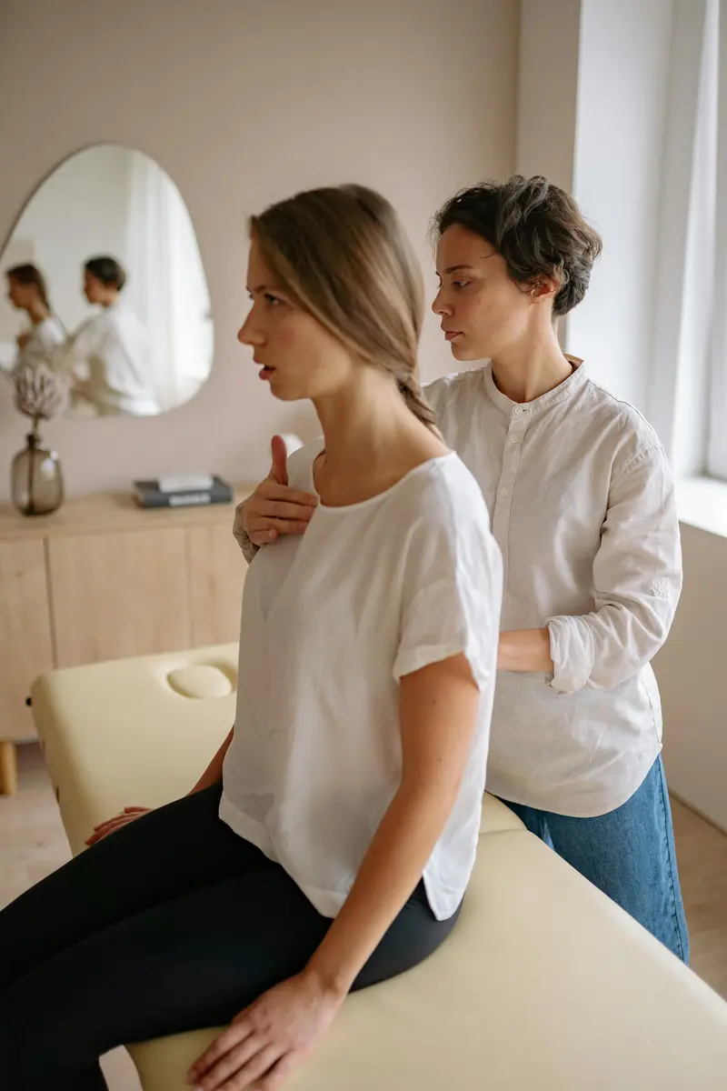 Physiotherapist assessing patient spinal posture and alignment in a modern clinic